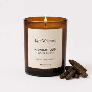 LybeWellness Midnight Oud scented candle in an amber glass jar with oud wood pieces beside it